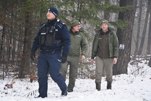 Policjanci i strażnicy WPN w zaśnieżonym lesie