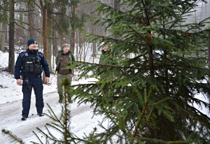 Policjanci i strażnicy WPN w zaśnieżonym lesie