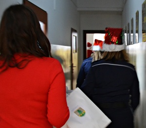 Policjantki i uczniowie niosą paczki świąteczne