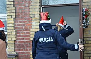 Policjantki przekazują dzieciom paczki świąteczne
