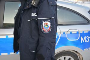mundur policjanta na tle radiowozu