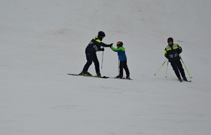 Policyjni narciarze na służbie, na stoku pomagają narciarzowi