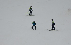 Policyjni narciarze na służbie, na stoku pomagają narciarzowi