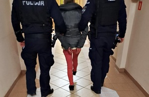 zatrzymana kobieta, doprowadzana przez policjantów