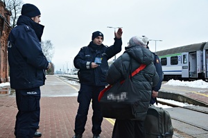 Dzielnicowi i funkcjonariusze SOK informują pasażerkę pociagu
