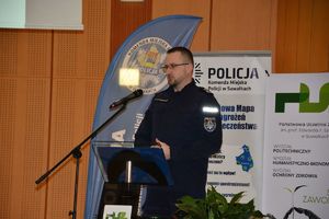 Policjant przemawia przy mównicy