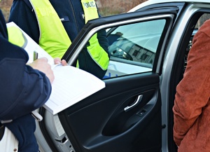 Policjant sprawdza trzeźwość kierowcy, wypełnia dokumentację