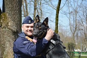 Policjant z psem służbowym w parku