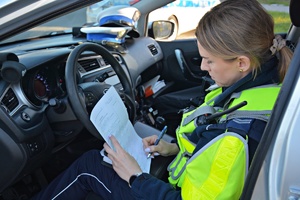 Policjantka sporządza dokumentację w radiowozie