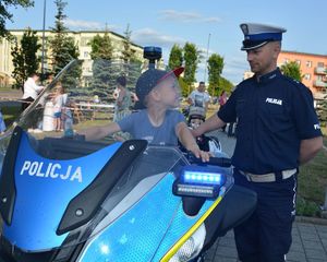 Policjant przy motocyklu na którym siedzi chłopczyk