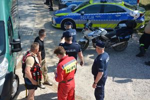 Policjanci i strażacy oraz radiowozy