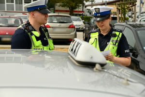 Dwoje policjantów WRD na tle &quot;koguta&quot; taksówki