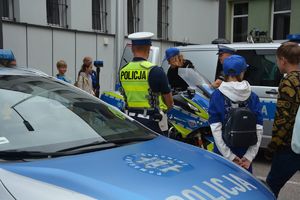 Policjanci i młodzież przy radiowozie