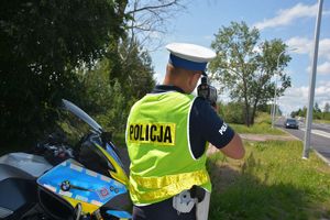 Policjant mierzy prędkość w tle motocykl