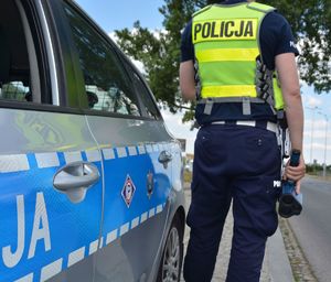Radiowóz i policjant z miernikiem prędkości