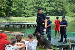 Policjanci rozmawiają z turystami nad jeziorem