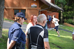Policjanci rozmawiają z turystami nad jeziorem