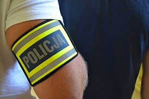 Policjant kryminalny doprowadza zatrzymanego