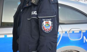 Naszywka na mundurze policjanta w tle radiowóz