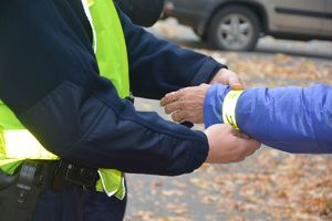 policjant zakłada odblask na rękę kobiety