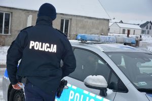 Zimowa aura policjant przy radiowozie