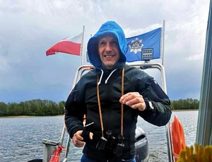 Policjant w po cywilnemu na łodzi policyjnej