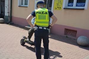 Policjant kontrolujący osobę poruszającą się na hulajnodze