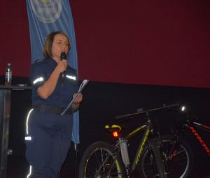 Policjantka z mikrofonem obok rowery