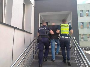 Dwóch policjantów prowadzi osobę zatrzyamną