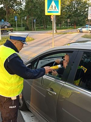 Policjant bada trzeźwość kierowców