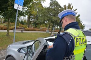 Policjant kontroluje kartę parkingową