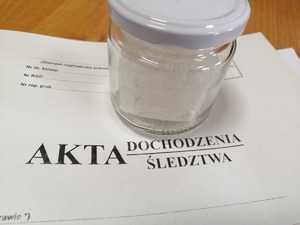 słoik z białym proszkiem stoi na aktach