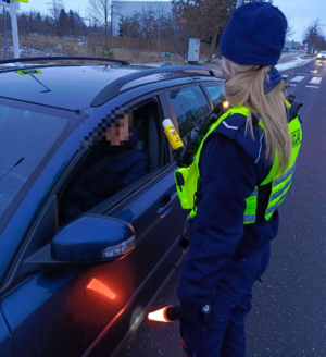 Policjantka ruchu drogowego bada trzeźwość