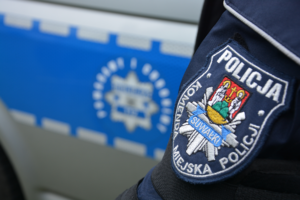 fragment munduru policjanta i radiowozu