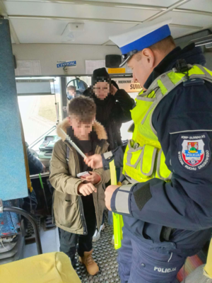 Policjant rozdaje odblaski w autobusie