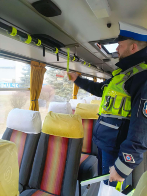 Policjant rozdaje odblaski w autobusie