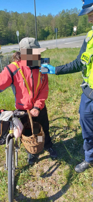 policjant przeprowadzający badanie na zawartość alkoholu  w wydychanym powietrzu