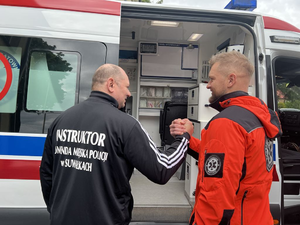 Policjant i ratownik medyczny na tle karetki