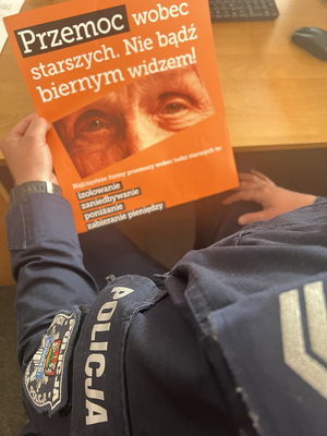 Policjant i plakat przemoc wobec osób starszych