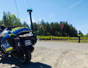 motocykl policjyjny koło przejazdu kolejowego