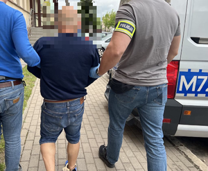 Policjant prowadzi zatrzymanego