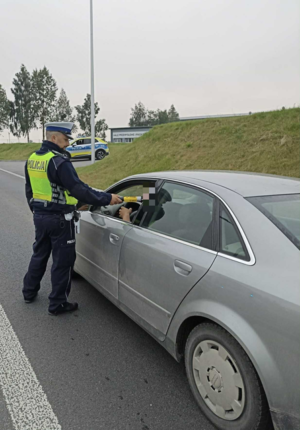 Policjant kontroluje trzeźwość kierowców