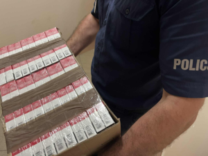 policjant trzyma karton z papierosami
