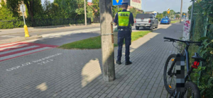 rower policjant ulica oraz przejście dla pieszych i pojazdy służbowe policji