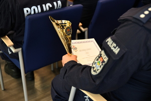 policjant trzyma puchar i dyplom