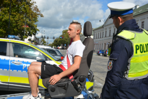 Mężczyzna na symulatorze zderzeń obok policjant
