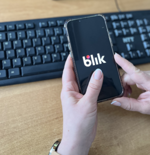 telefon w dłoniach napis blik