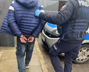 policjant prowadzi zatrzymanego