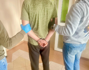 policjanci z zatrzymanym w kajdankach