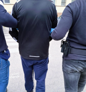 policjanci powadzą zatrzymanego w kajdankach